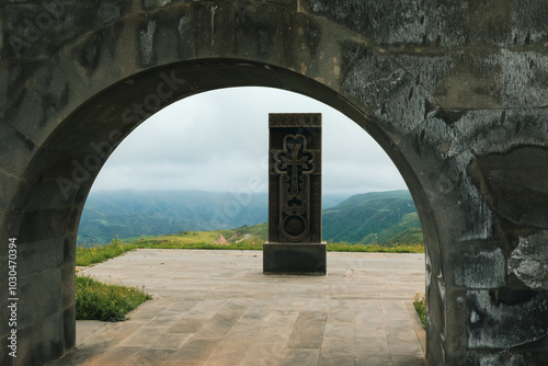 A historical monument stands in Nagorno Karabakh, surrounded by serene landscapes on a cloudy day photo