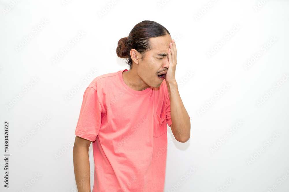 Asian, Indonesian man with long hair and bored face, sleepy and yawning standing wearing pink shirt. isolated on white background Asian, Indonesian man with long hair and bored face, sleepy and yawning standing wearing pink shirt. isolated on white background