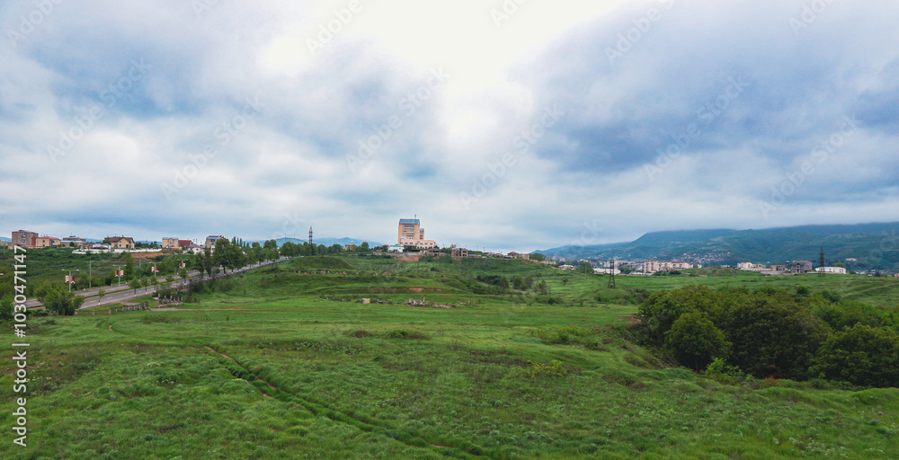 Aerial view of Nagorno Karabakh landscape with rolling hills and modern architecture under cloudy skies Aerial view of Nagorno Karabakh landscape with rolling hills and modern architecture under cloudy skies