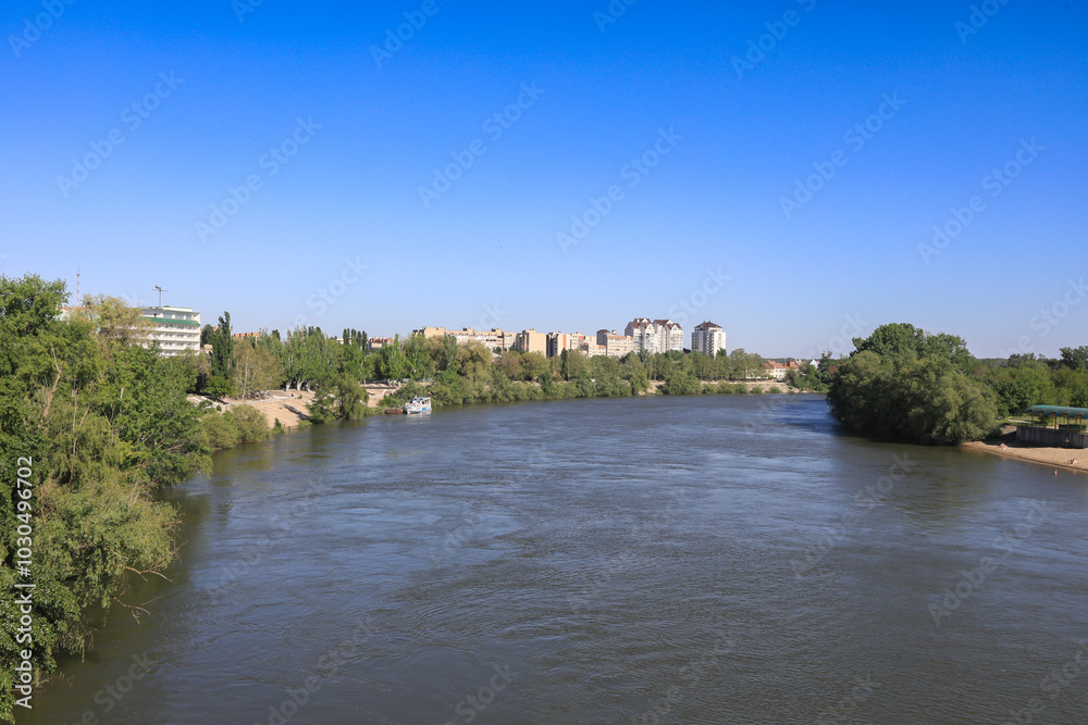 Tranquil river view in Tiraspol, Prednestrovie with clear skies and lush greenery Tranquil river view in Tiraspol, Prednestrovie with clear skies and lush greenery