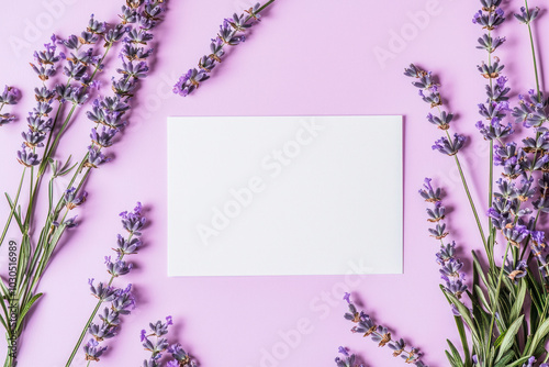 Lavender pink background. Festive holiday greeting card for Birthday, Woman or Mothers Day, blank copy paper and a greeting card. View from above.