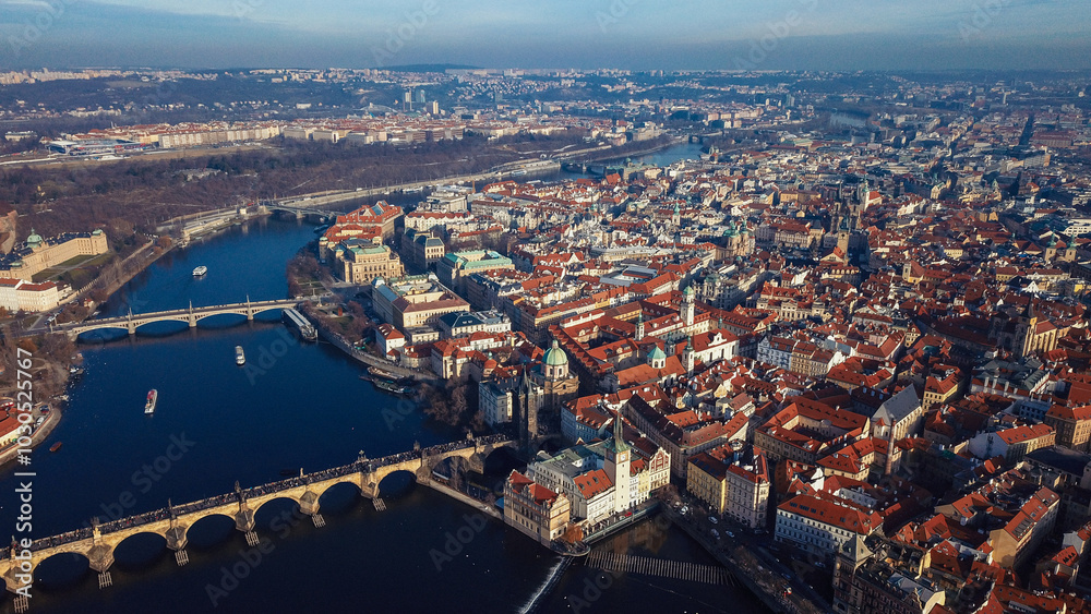 Obraz premium Aerial view of Prague showcasing the cityscape bridges and Vltava River during sunny daylight hours
