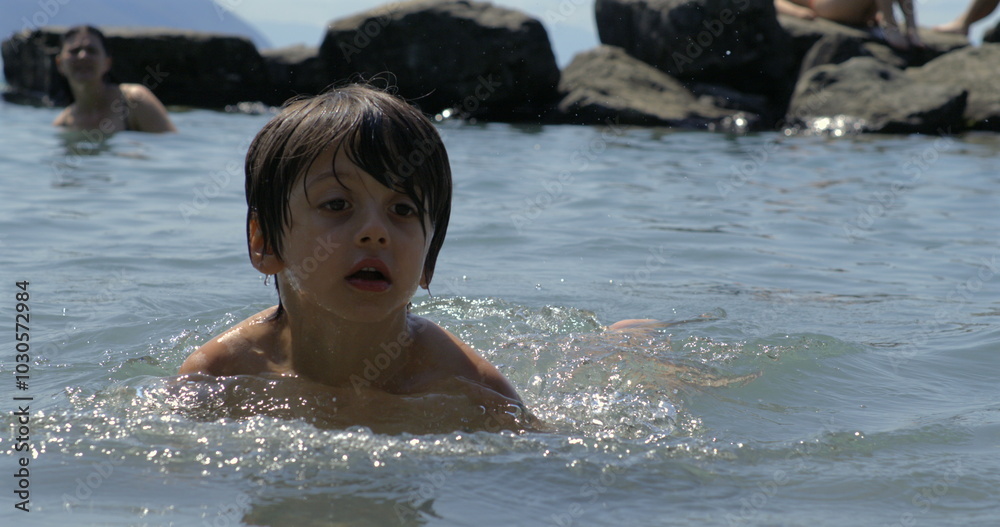 Child splashing water in slow motion at 800 fps, enjoying a fun swim in the lake with friends, capturing the essence of carefree summer days Child splashing water in slow motion at 800 fps, enjoying a fun swim in the lake with friends, capturing the essence of carefree summer days