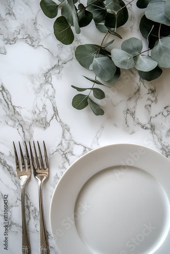 Elegant white plate with a fork and eucalyptus branch on marble background photo