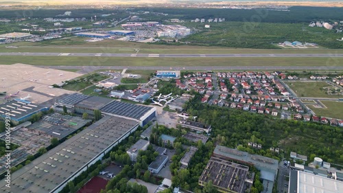 Aerial footage of Bucharest international airport aurel vlaicu on a summer afternoon. Helicopter footage of landing strip, airplanes, hangars and infrastructure surrounding the airfield. 
 photo