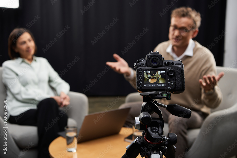A middle-aged female journalist engages an expert during a professional interview in a modern studio. A middle-aged female journalist engages an expert during a professional interview in a modern studio.