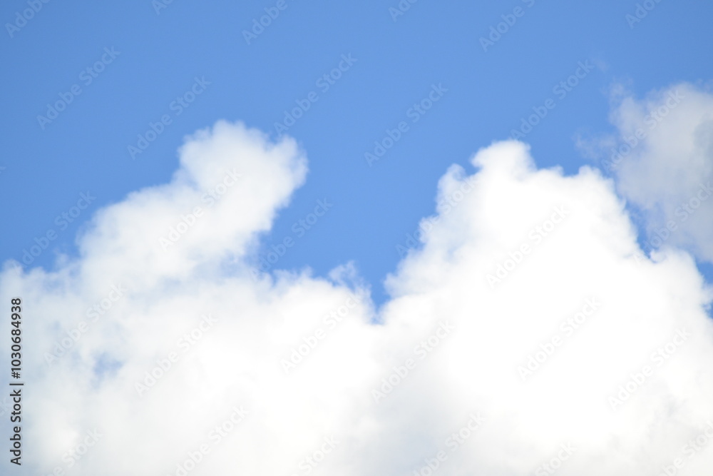 fluffy white clouds drifting across a clear blue sky. The sun is shining brightly, casting a warm glow on the scene. The image evokes feelings of peace, tranquility fluffy white clouds drifting across a clear blue sky. The sun is shining brightly, casting a warm glow on the scene. The image evokes feelings of peace, tranquility