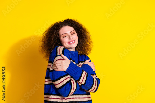 Portrait of gorgeous nice girl with wavy hairstyle wear knit pullover embrace herself eyes closed isolated on yellow color background