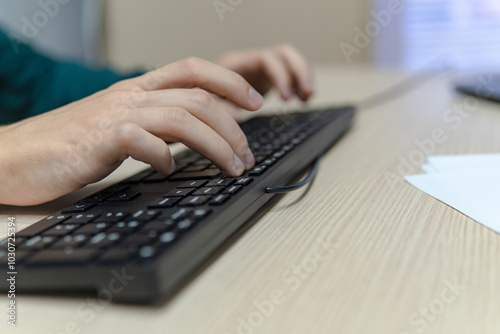 Close up businessman hands using a computer in the office, side view, typing the keyboard, business concept