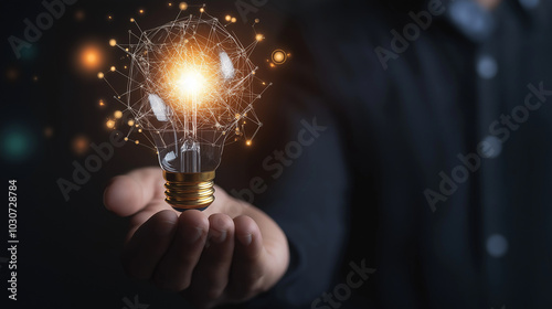 Businessman holding creative light bulb with growth graph, analytics icons. Utilizing analytics technology to develop new strategies and insights that enhance successful performance in global business