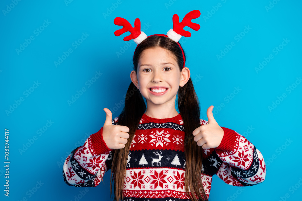 Photo of funny cheerful cute girl wear ugly ornament sweater christmas party thumb up isolated on blue color background Photo of funny cheerful cute girl wear ugly ornament sweater christmas party thumb up isolated on blue color background