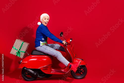 Full body portrait of pretty aged lady bike new year x-mas gifts isolated on vibrant red color background