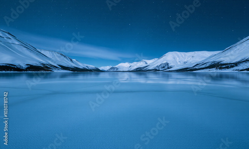 a frozen lake surrounded by snow-covered mountains photo