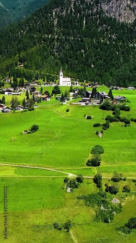 Wallpaper Mural Isolated Swiss village with mountains forests and grasslands aerial view, vertical video. Torontodigital.ca
