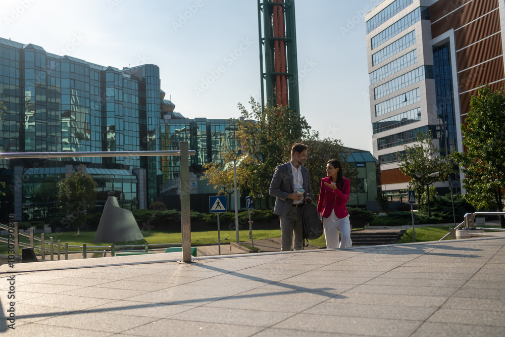Obraz premium Business people, walking and travel in city with discussion on morning commute, partnership and happy. Employees, man and woman with conversation, collaboration and networking outdoor in urban town 