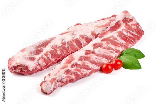 Raw pork ribs with basil leaves and cherry tomatoes, isolated on white background.