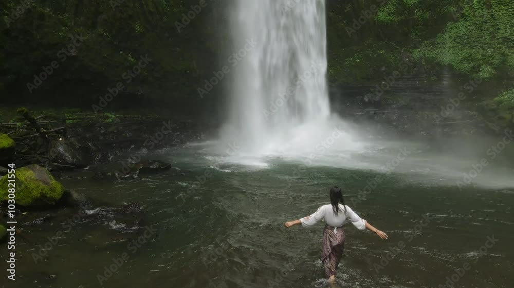 Young Woman Enjoying Nature and Walking in Front of a Waterfall. Young Woman Enjoying Nature and Walking in Front of a Waterfall.