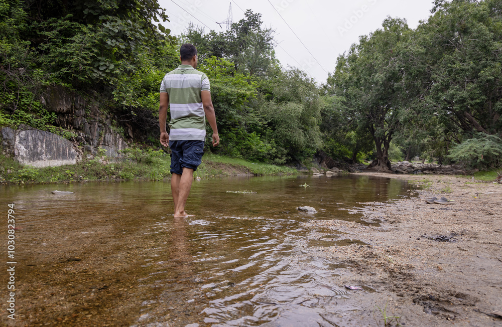 Isolated Man Walking in Natural River Stream During Morning Isolated Man Walking in Natural River Stream During Morning