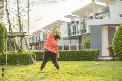 Overweight Asian women practice yoga in the park to strengthen their body and help them lose weight.Young woman is happy to motivation exercise or outdoor in the garden to control or lose weight
