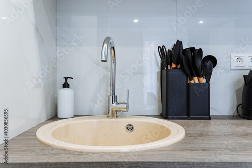 This is a kitchen sink that features a functional faucet as well as a handy soap dispenser conveniently placed on the countertop for easy access while washing dishes or hands photo