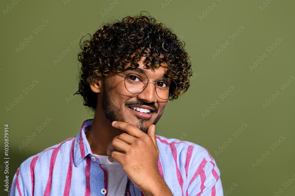 Photo of smart minded guy with wavy hairdo dressed striped shirt in glasses touching chin thinking isolated on khaki color background Photo of smart minded guy with wavy hairdo dressed striped shirt in glasses touching chin thinking isolated on khaki color background
