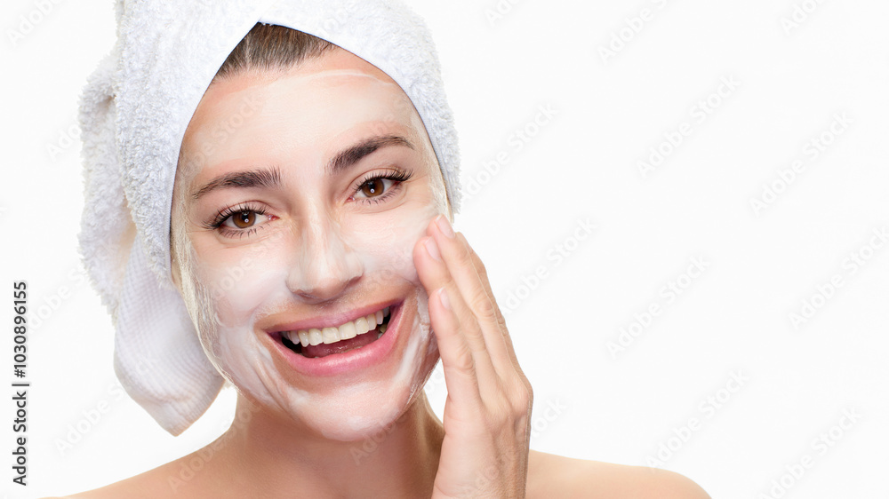Woman applying face mask for skincare with towel on head Woman applying face mask for skincare with towel on head
