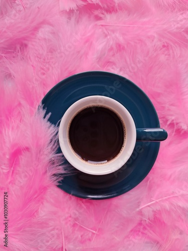 Cup of coffee on pink feathers