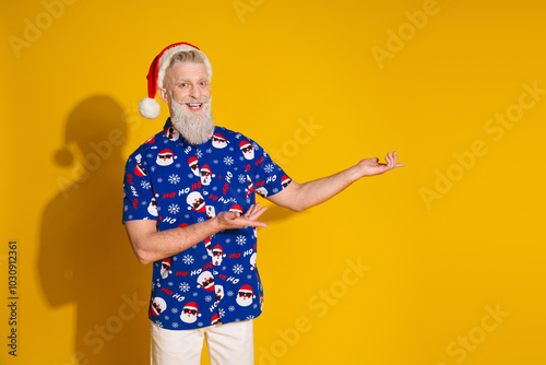 Portrait of modern stylish santa hands show empty space proposition new year xmas print shirt isolated on yellow color background