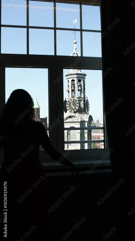 Silhouette of a person admiring Amsterdam's historic clock tower Silhouette of a person admiring Amsterdam's historic clock tower