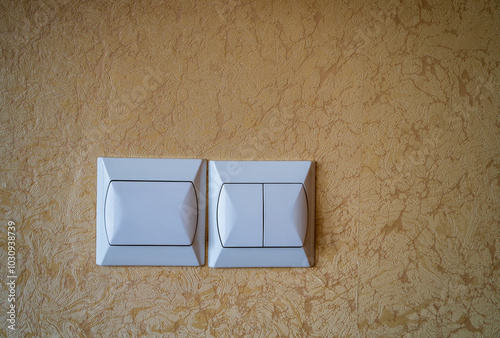 Obraz na płótnie Two white light switches mounted on a textured beige wall. w salonie