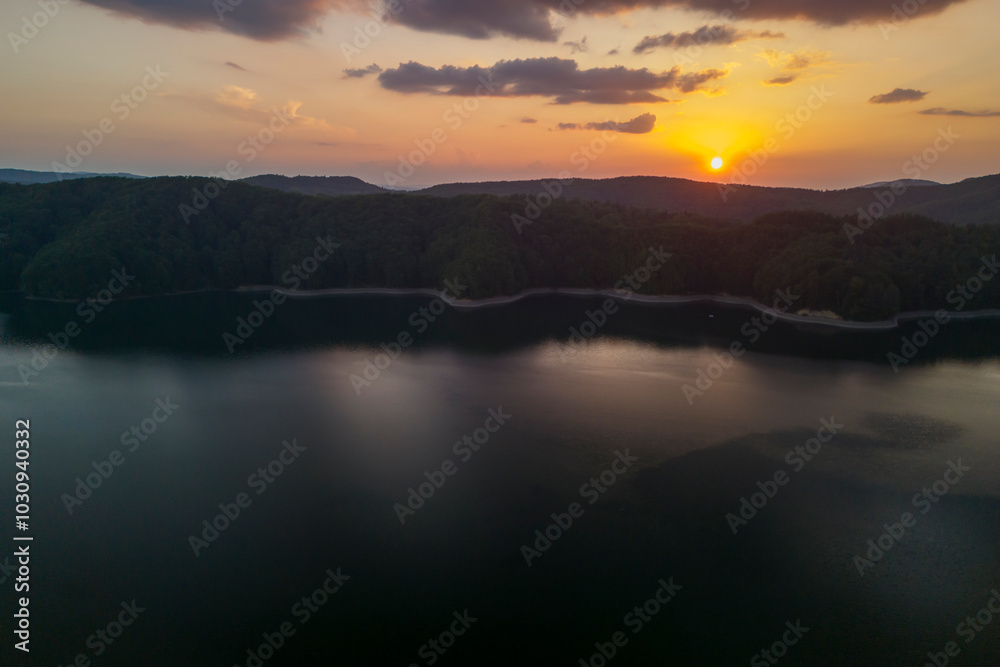 A stunning sunset over a tranquil lake surrounded by lush forests. The calm water reflects vibrant colors, creating a serene and picturesque landscape perfect for nature lovers. A stunning sunset over a tranquil lake surrounded by lush forests. The calm water reflects vibrant colors, creating a serene and picturesque landscape perfect for nature lovers.