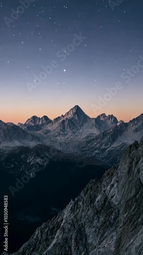 Mountain range at dawn with starry sky