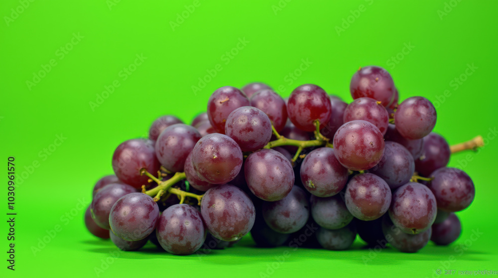 Obraz premium High-Quality Image of Fresh Purple Grapes on Vibrant Green Background - Ideal for Food, Health, and Marketing Projects