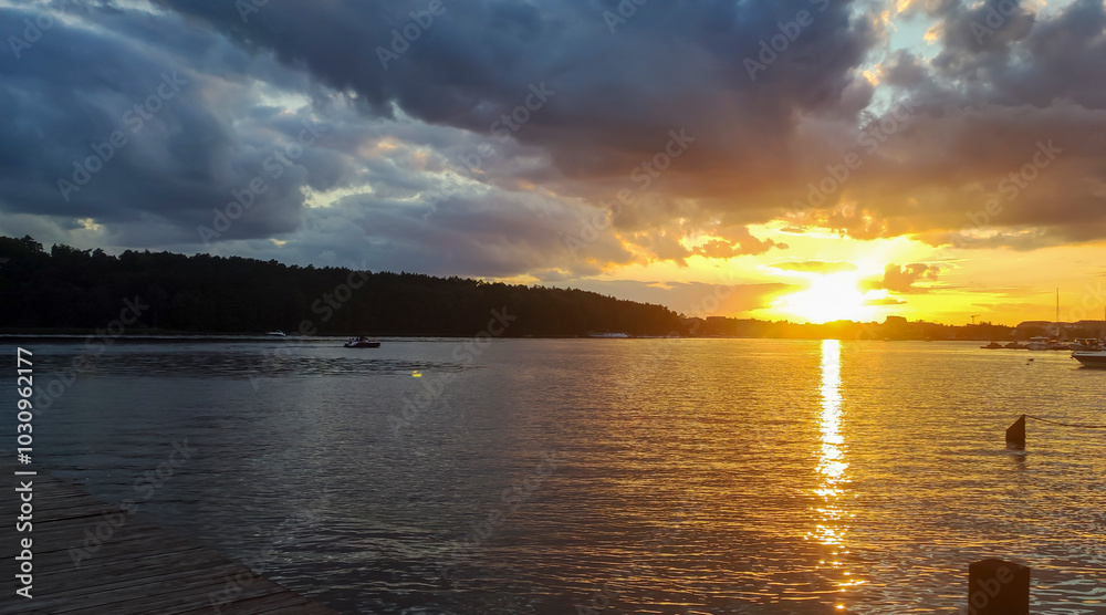 Stunning sunset over a serene lake with vibrant colors reflected in the water and a silhouette of trees in the background Stunning sunset over a serene lake with vibrant colors reflected in the water and a silhouette of trees in the background