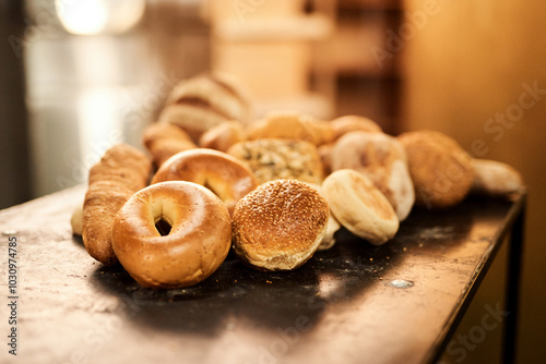 Rolls, bakery and table with bread for wheat, food or pastry production at warehouse or factory. Closeup, baking and mix with ingredients or fresh produce on counter for breakfast, dough or heast photo