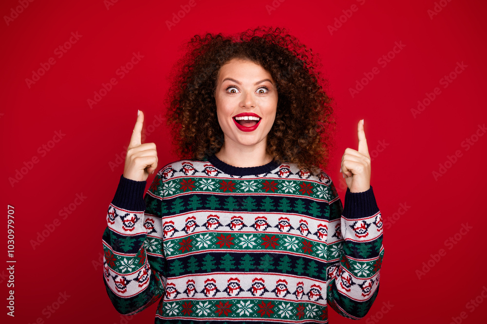 Portrait of nice young girl indicate fingers up empty space wear new year xmas sweater isolated on red color background Portrait of nice young girl indicate fingers up empty space wear new year xmas sweater isolated on red color background