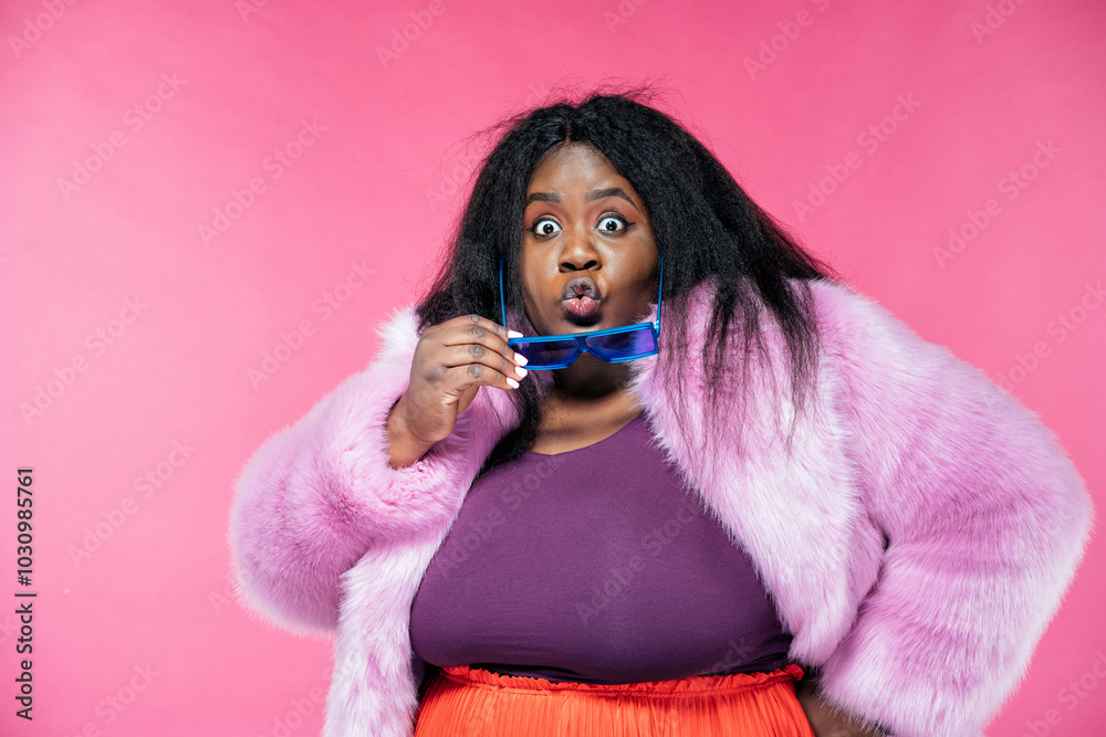 Image of a beautiful woman posing in a furry coat on a pink background Image of a beautiful woman posing in a furry coat on a pink background