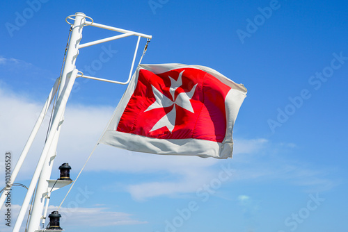 Schilderij op canvas Maltese flag on the stern of a cruise ship against a blue sky background