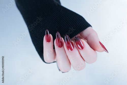 Female hands with long nails and black and red nail polish photo