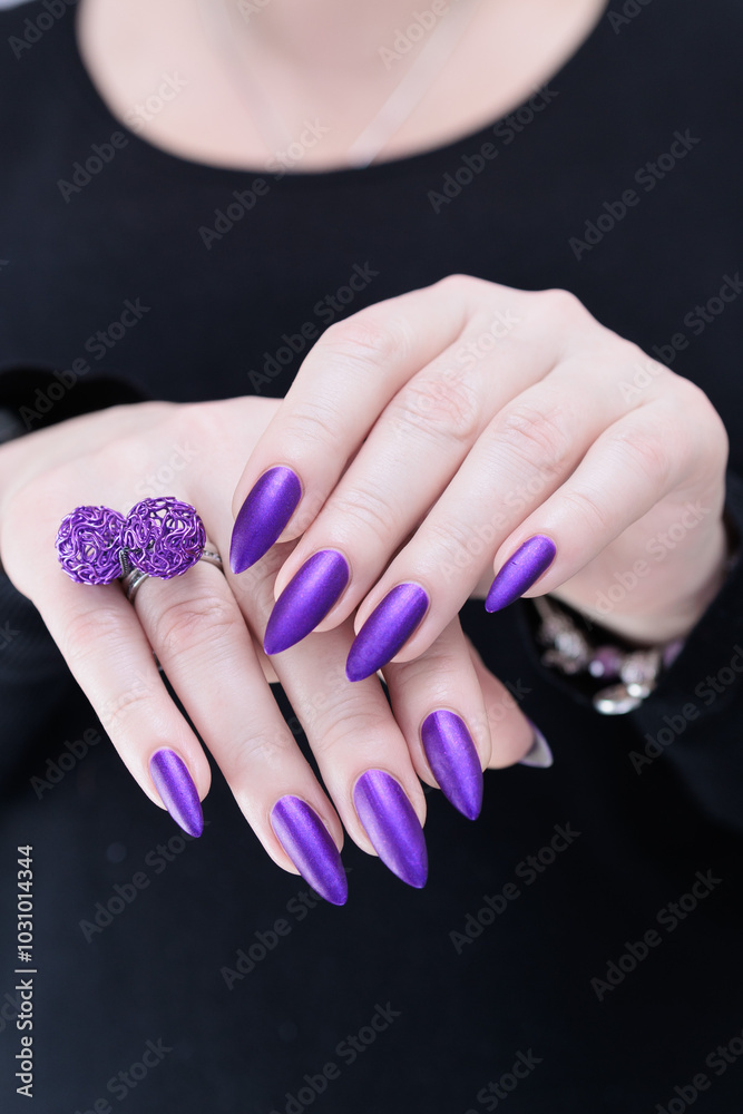 Fototapeta premium Female hand with long nails and a blue and purple color nail polish