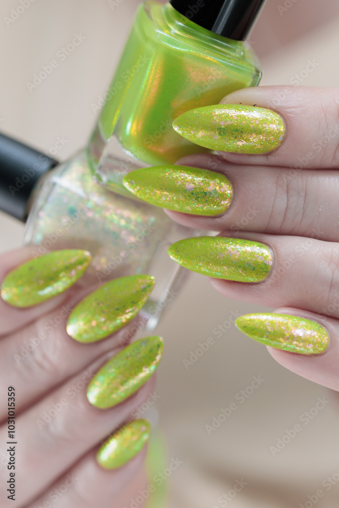 Female hand with long nails and a yellow green nail polish Female hand with long nails and a yellow green nail polish