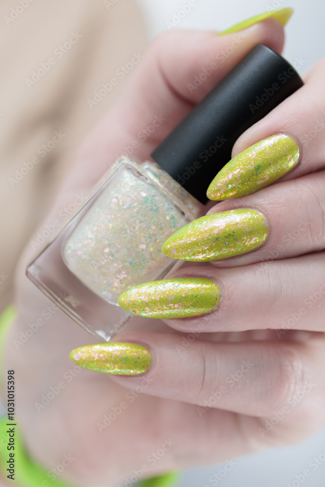 Female hand with long nails and neon yellow green manicure Female hand with long nails and neon yellow green manicure