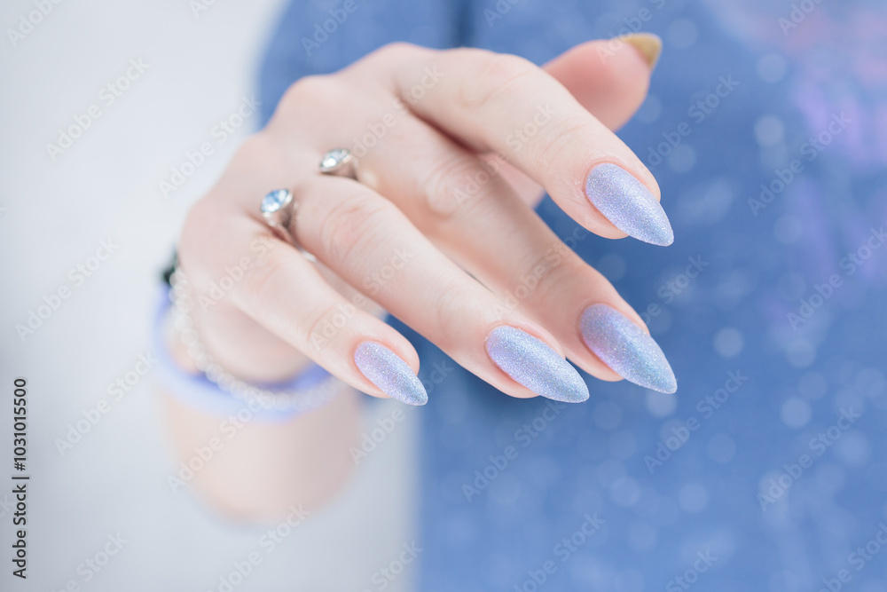 Woman hand with long nails manicure and light lilac and blue nail polish