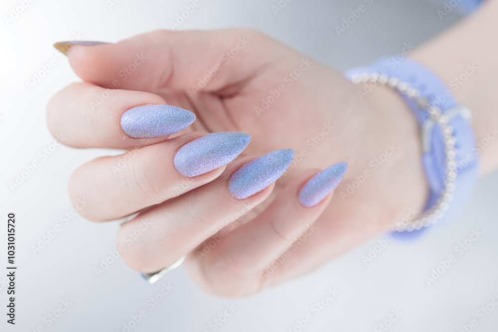 Woman's beautiful hand with long nails and light blue and lilac manicure Woman's beautiful hand with long nails and light blue and lilac manicure