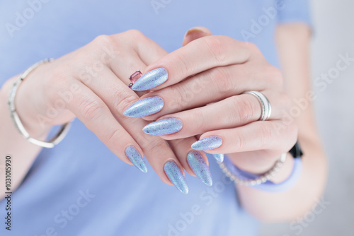 Woman hand with long nails manicure and light lilac and blue nail polish