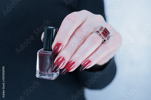 Female hands with long nails and black and red nail polish photo