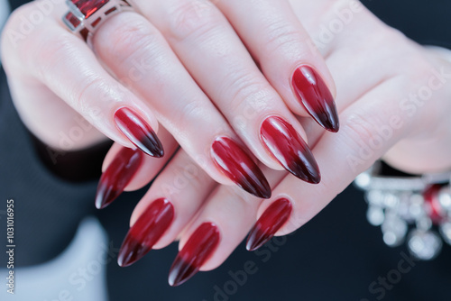 Female hands with long nails and black and red nail polish photo