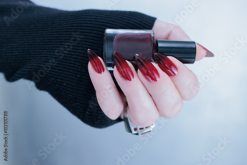 Female hands with long nails and black and red nail polish photo