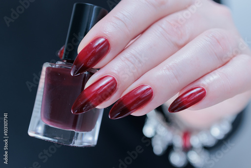 Female hands with long nails and black and red nail polish photo