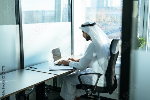 Canvas Print handsome man with traditional clothes working in an office of Dubai
